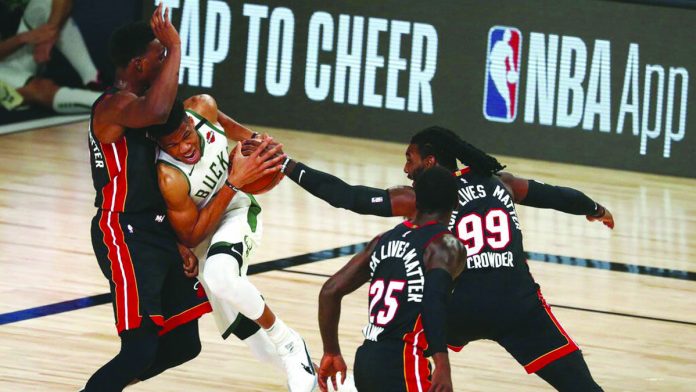 Milwaukee Bucks’ Giannis Antetokounmpo works his way past Miami Heat’s Bam Adebayo as Jae Crowder tries to help and Kendrick Nunn looks on. Milwaukee Bucks’ Giannis Antetokounmpo works his way past Miami Heat’s Bam Adebayo as Jae Crowder tries to help and Kendrick Nunn looks on. AP
