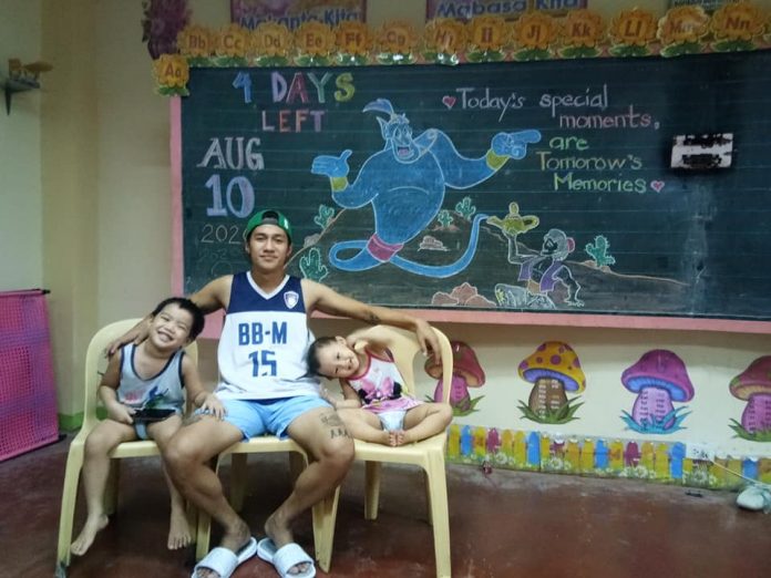 Mitchelle “Bon” Silaya holds classes to his children Alfonzo and Brianna inside their quarantine facility Mitchelle “Bon” Silaya holds classes to his children Alfonzo and Brianna inside their quarantine facility at a public elementary school in Bago City, Negros Occidental on Aug. 10. BON SILAYA