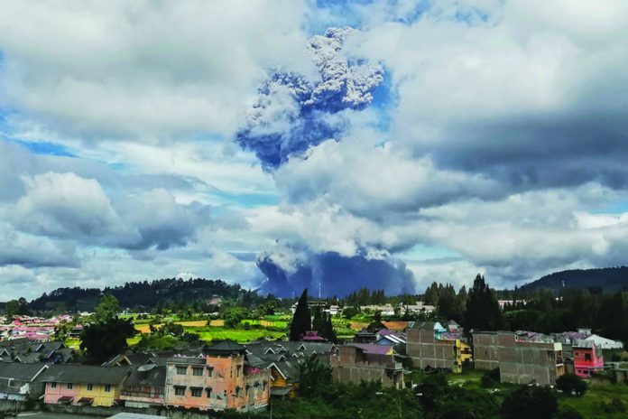 Indonesia Volcano Mount Sinabung spews volcanic materials into the air as it erupts, in Karo, North Sumatra, Indonesia, Monday. AP