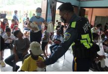 Police officers distribute gift packs to children at SOS Children’s Village in Zarraga, Iloilo. PRO-6 PHOTO