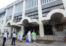 Personnel of the Iloilo City Health Office and Bureau of Fire Protection wearing protective gear as they disinfect the entrance of the Chief Justice Ramon Q. Avanceña Hall of Justice on Friday as part of the precautionary measure to stop the spread of coronavirus disease 2019. IAN PAUL CORDERO/PN