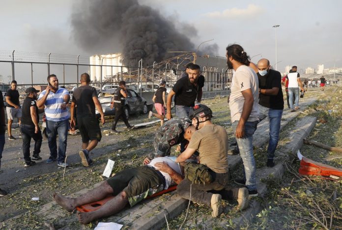 Rescue workers help an injured man at the explosion scene that hit the seaport of Beirut, Lebanon, Tuesday, Aug. 4, 2020 Rescue workers help an injured man at the explosion scene that hit the seaport of Beirut, Lebanon, Tuesday, Aug. 4, 2020. AP Photo/Hussein Malla