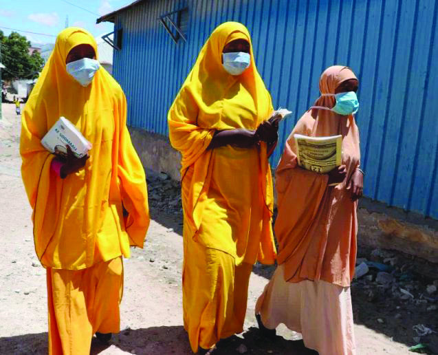 Students wearing face masks walk in a Mogadishu neighborhood on March 19, 2020 in Somalia. AFP/GETTY IMAGES