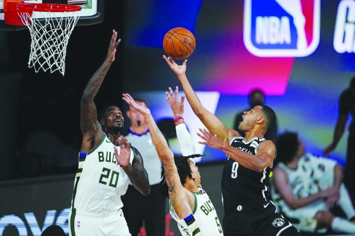 Timothe Luwawu-Cabarrot of Brooklyn Nets attempts a basket against the defense of Milwaukee Bucks’ Marvin Williams (20) and DJ Wilson (5) Timothe Luwawu-Cabarrot of Brooklyn Nets attempts a basket against the defense of Milwaukee Bucks’ Marvin Williams (20) and DJ Wilson (5). AP
