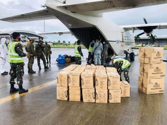 Uniformed officers help move boxes of food packs and relief goods from a private aircraft of AC Energy Philippines at the Iloilo Airport Uniformed officers help move boxes of food packs and relief goods from a private aircraft of AC Energy Philippines at the Iloilo Airport in Cabatuan, Iloilo. After this, the boxes are carefully disinfected to make sure they are free from the coronavirus. These goods are for families affected by the recent oil spill. RELIEF GOODS