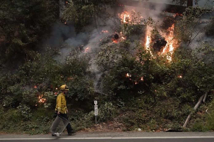 AP A firefighter walks along Highway 9 while monitoring flames from the CZU August Lightning Complex Fire on Aug. 22, 2020 in Boulder Creek, California, United States. A firefighter walks along Highway 9 while monitoring flames from the CZU August Lightning Complex Fire on Aug. 22, 2020 in Boulder Creek, California, United States. AP