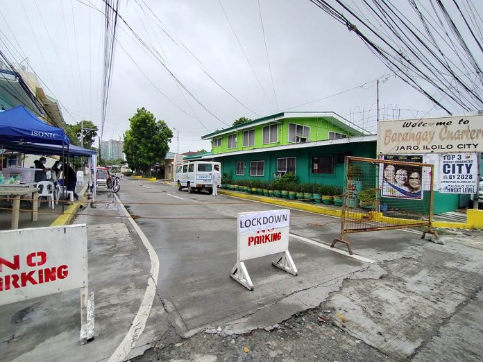 The entrance to Barangay Cuartero in Iloilo City’s Jaro district is barricaded with “lockdown” signs. A specimen extraction point has also been set up in the village after four residents there tested positive for coronavirus disease 2019. IAN PAUL CORDERO/PN