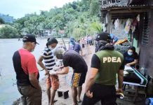 An antidrug officer confiscates items from Winston Jim Gonzales, who was nabbed in a buy-bust operation in Barangay Rizal, Jordan, Guimaras on Aug. 1. PDEA-6