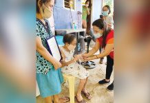 Ceferina "Pinang" Cornel (seated), 100, receives her cash aid and letter of felicitation on Tuesday in Nueva Valencia, Guimaras. VICE MAYOR PAUL VINCENT DELA CRUZ/FB