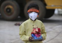 India eases virus restrictions as cases near 3.7 million An Indian child wearing a mask as a precaution against the coronavirus carries an idol of elephant-headed Hindu god Ganesha to immerse in Saroornagar Lake on the final day of Ganesh Chaturthi festival in Hyderabad, India, Tuesday, Sept. 1, 2020. AP