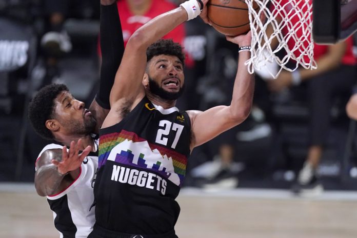 Denver Nuggets’ Jamal Murray goes up for a shot as Clippers’ Paul George defends Denver Nuggets’ Jamal Murray goes up for a shot as Clippers’ Paul George defends during the second half on Sunday in Orlando, Florida. MARK J. TERRILL / AP