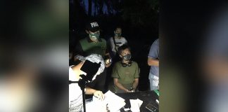 Drug suspect Jerald Esmeralda sits handcuffed while antidrug personnel conduct an inventory of items seized from him in an entrapment operation in Barangay Pook, Kalibo, Aklan on Sept. 4. BOY RYAN ZABAL/AKEAN FORUM