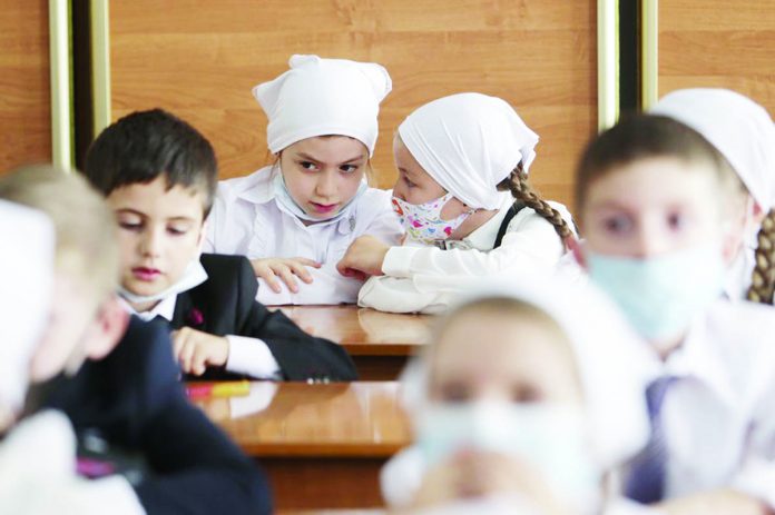 Pupils wearing face masks to protect against coronavirus sit in a classroom during a ceremony Pupils wearing face masks to protect against coronavirus sit in a classroom during a ceremony marking the start of classes at a school as part of the traditional opening of the school year known as "Day of Knowledge" in Grozny, Russia, Tuesday, Sept. 1, 2020. Across the country, schools start their usually festive opening day on Sept. 1. AP