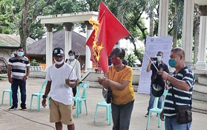 reds unwelcome WITHDRAWAL OF SUPPORT. Former mass supporters of the Communist Party of the Philippines-New People’s Army in Barangay Sta. Rosa, Murcia, Negros Occidental burn the CPP-NPA flag in a ceremony held at the village covered court on Sept. 21, 2020. PHILIPPINE ARMY’S 79TH INFANTRY BATTALION