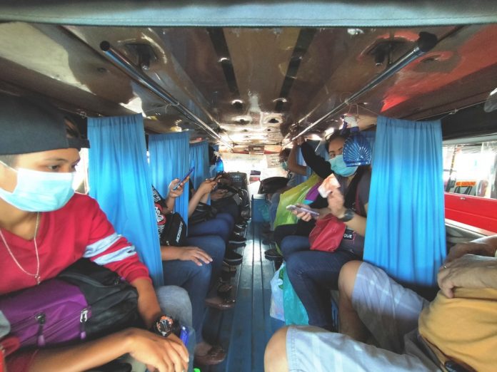 people inside a jeepney IS THIS TOO CLOSE FOR COMFORT? Non-porous curtains separate anxious passengers of this public utility jeepney in Iloilo City to prevent coronavirus transmission. The Department of Transportation is easing physical distancing in public utility vehicles. Not everyone is happy. COVID-19 spreads mainly among people who are in close contact for a prolonged period. Spread happens when an infected person coughs, sneezes or talks, and droplets from their mouth or nose are launched into the air and land in the mouths or noses of people nearby. IAN PAUL CORDERO/PN