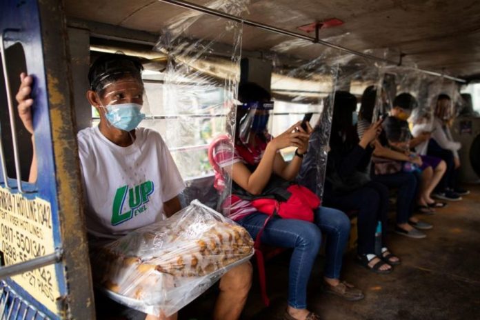 Jeepney passengers seated between plastic barriers, Jeepney passengers seated between plastic barriers, wear face masks and face shields mandatory in public transportation, to help curb coronavirus infections, in Quezon City, Metro Manila on Aug. 19, 2020. ELOISA LOPEZ/REUTERS