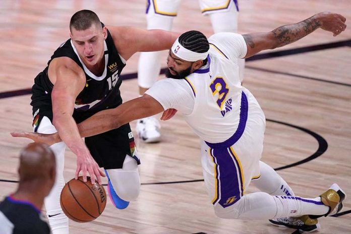 nba Denver Nuggets center Nikola Jokić (left) and Lakers forward Anthony Davis battle for a loose ball during the first half of Game 3. MARK J. TERRILL / ASSOCIATED PRESS