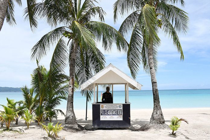 PHILIPPINES-HEALTH-VIRUS-TOURISM A policeman standing guard along the empty famous white beach of Boracay Island in Malay, Aklan. Tourists from areas under general community quarantine may enjoy what the famed-island resort offers starting next month, says Tourism secretary Bernadette Puyat. ERNESTO CRUZ/AFP