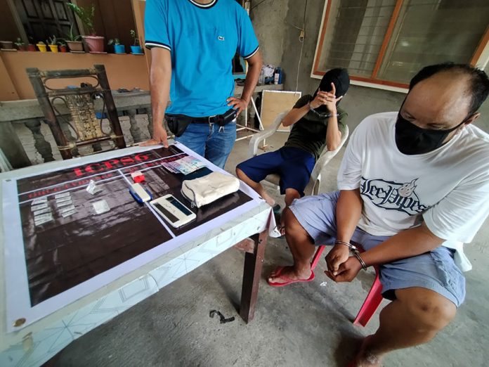 Drug suspects John Winston Porras and Fritz Simbre look on as a police operative presents the items recovered from a buy-bust operation in Barangay Poblacion, Leganes, Iloilo. Porras and Simbre face a charge for violation of the Comprehensive Dangerous Drugs Act of 2002. IAN PAUL CORDERO/ PN Drug suspects John Winston Porras and Fritz Simbre look on as a police operative presents the items recovered from a buy-bust operation in Barangay Poblacion, Leganes, Iloilo. Porras and Simbre face a charge for violation of the Comprehensive Dangerous Drugs Act of 2002. IAN PAUL CORDERO/ PN