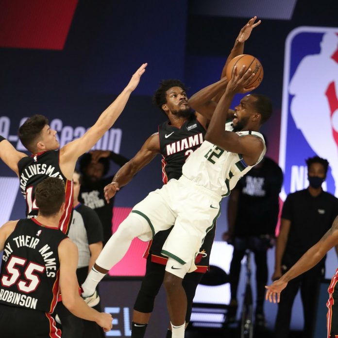 Milwaukee Bucks’ Khris Middleton attempts a tough basket against the defense of Miami Heat’s Jimmy Butler and Tyler Herro. NBA PHOTO Milwaukee Bucks’ Khris Middleton attempts a tough basket against the defense of Miami Heat’s Jimmy Butler and Tyler Herro. NBA PHOTO