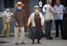 Domestic air travel back in Wuhan, China An elderly couple wearing face masks to protect against the coronavirus walks at a public park in Beijing, Saturday, Sept. 12, 2020. MARK SCHIEFELBEIN/AP PHOTO