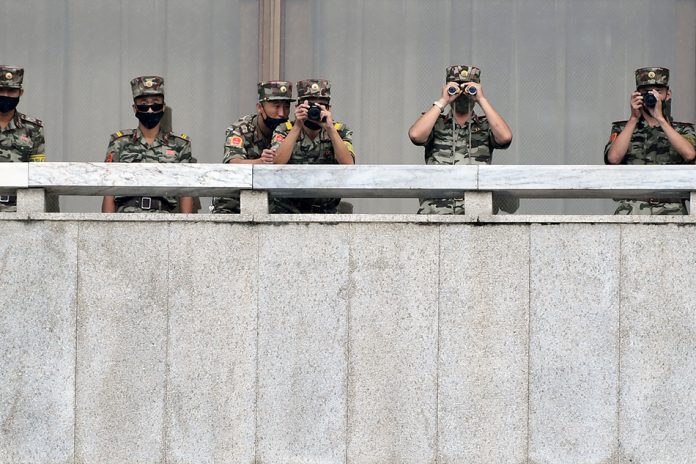 N. Kor Soldiers keep watch North Korean soldiers keep watch toward the south as South Korean Unification Minister Lee In-young inspects (not pictured) the truce village of Panmunjom inside the demilitarized zone separating the two Koreas. KOREA POOL/REUTERS