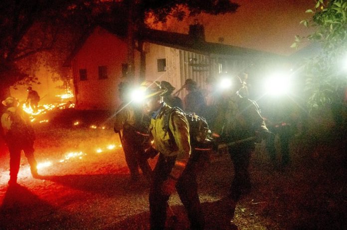 A hand crew works to save a home as the Bear Fire burns through the Berry Creek area of Butte County, Calif., on Wednesday, Sept. 9, 2020. NOAH BERGER/AP PHOTO A hand crew works to save a home as the Bear Fire burns through the Berry Creek area of Butte County, Calif., on Wednesday, Sept. 9, 2020. NOAH BERGER/AP PHOTO