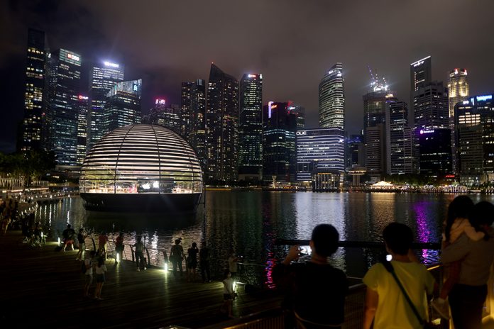singapore sees popu drop People take photos of the upcoming Apple Marina Bay Sands store in Singapore Sept. 8, 2020. EDGAR SU/REUTERS