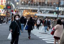 Japan to start easing travel advisory A woman wearing a protective face mask runs across a street at Shibuya in Tokyo, Japan. ATHIT PERAWONGMETHA/REUTERS