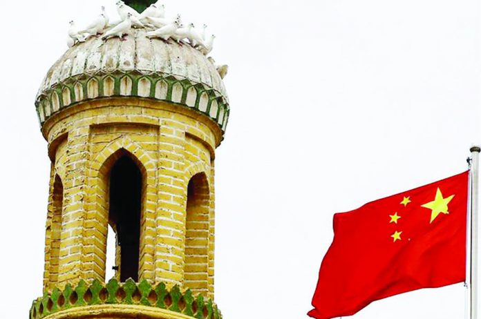 US-China 2_c A Chinese national flag flutters near a minaret of the ancient Id Kah Mosque in the Old City in Kashgar in Xinjiang Uighur Autonomous Region, China September 6, 2018. REUTERS