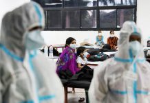 A woman sits with her child inside a quarantine center for COVID-19 patients amidst the spread of the disease at an indoor sports complex in New Delhi, India, September 22, 2020. REUTERS