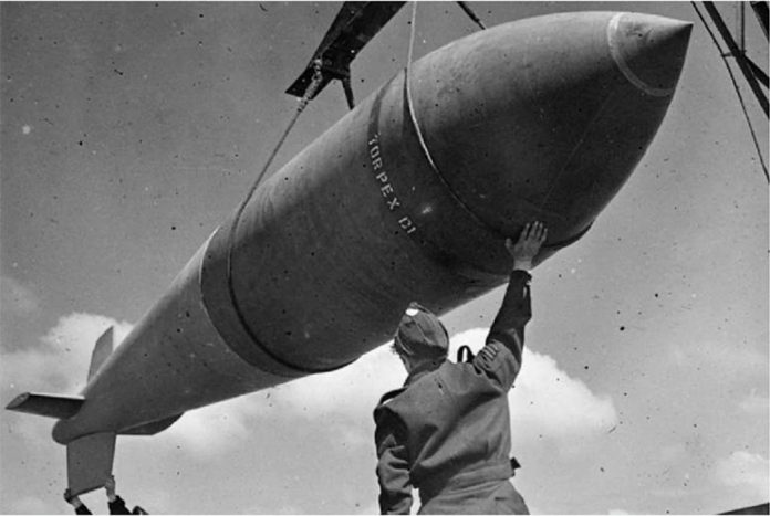 bomb A 12,000-lb MC deep-penetration bomb is hoisted from the bomb dump to its carrier at Woodhall Spa, Lincolnshire