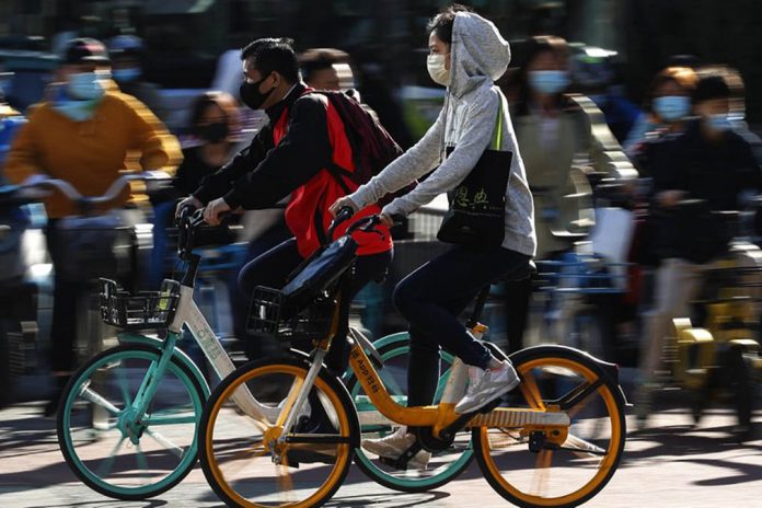 china People wearing face masks to help curb the spread of the coronavirus ride bicycle during the morning rush hour in Beijing on Oct. 12. ANDY WONG/AP PHOTO