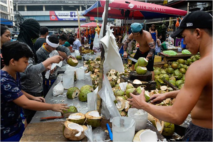 coco Workers crack open coconuts at a public market near Taft Avenue in Pasay City. GEORGE CALVELO/ABS CBN NEWS