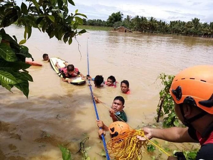 Rescuers use ropes to help residents flee from rising floodwaters in Sipalay City, Negros Occidental on Oct. 7. According to the country’s weather bureau, La Niña is expected to adversely affect the entire Visayas region this month until March next year. SIPALAY CITY DRRMO