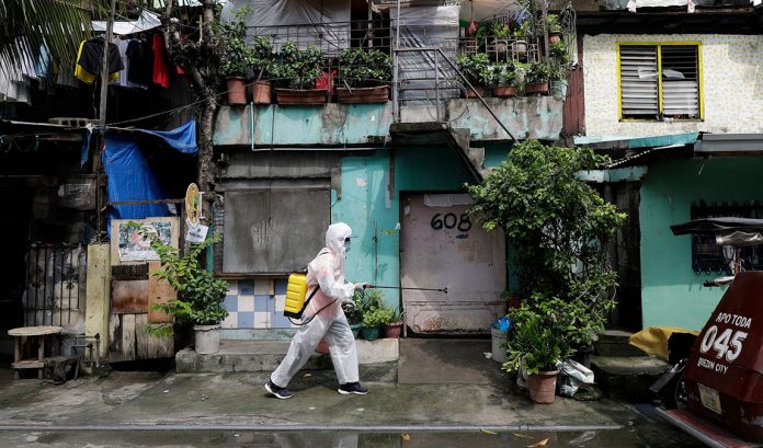 APTOPIX Virus Outbreak Philippines A man wearing a protective suit disinfects an area placed under lockdown measures to curb the spread of COVID-19 in Caloocan City, Philippines. AARON FAVILA/AP PHOTO