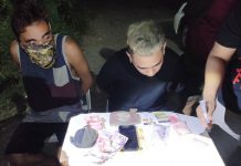 Drugs suspects Welvin John Lebrilla (right) of Barangay Pandac, Pavia and his alleged cohort 30-year-old Jessie Jay Lizada of Barangay Balabag, Pavia sits handcuffed while operatives conduct an inventory of the seized illegal drugs in a buy-bust operation around 9 p.m. on Oct. 4. JIRO SHEEN EMILIO/PN
