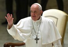 Pope Francis waves during his weekly general audience in the Paul VI hall at the Vatican on Oct. 14, 2020. ALBERTO PIZZOLI/AFP