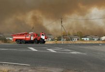 Fire trucks are seen on the road as smoke rises from the site of a fire at an ammunition depot in Ryazan Region, Russia Oct. 7, 2020. RUSSIAN EMERGENCIES MINISTRY IN RYAZAN REGION/HANDOUT VIA REUTERS