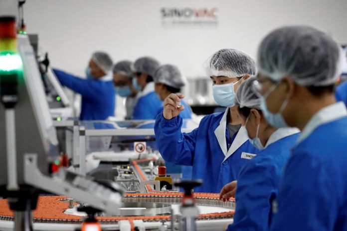 People work in the packaging facility of Chinese vaccine maker Sinovac Biotech, developing an experimental coronavirus vaccine, during a government-organized media tour in Beijing, China on Sept. 24, 2020. THOMAS PETER/ REUTERS