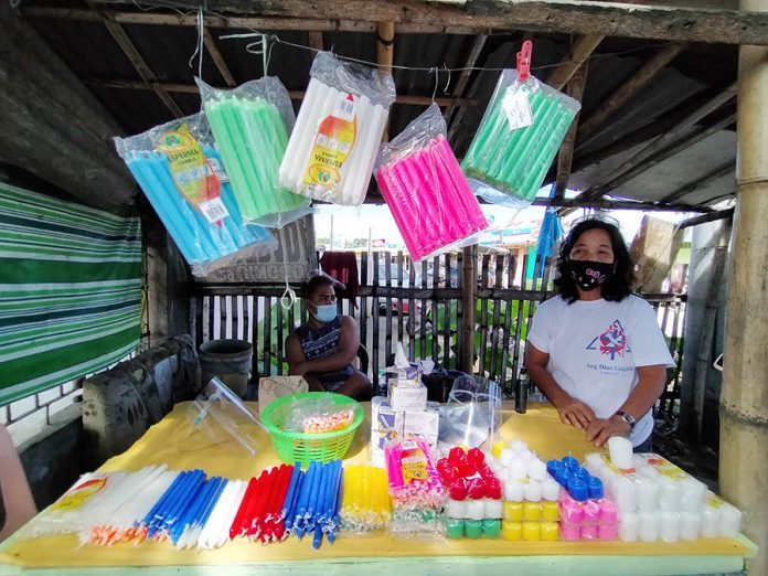 vendors cemetery Elena Paciente sells candles outside the public cemetery of Santa Barbara, Iloilo on Oct. 28. She laments the slow crawl of sales as authorities order a weeklong shutdown of cemeteries to avoid massive gathering that could increase risk of coronavirus transmission. IAN PAUL CORDERO/PN
