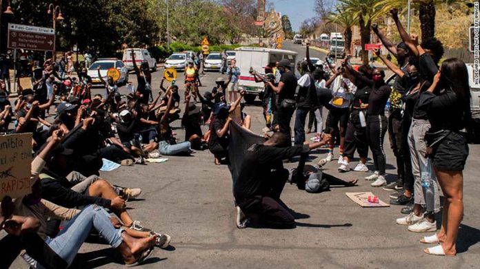 Protesters hold placards during the second day of the #ShutItDown Protests in Windhoek’s Central Business District on Oct. 9, 2020. AFP PHOTO