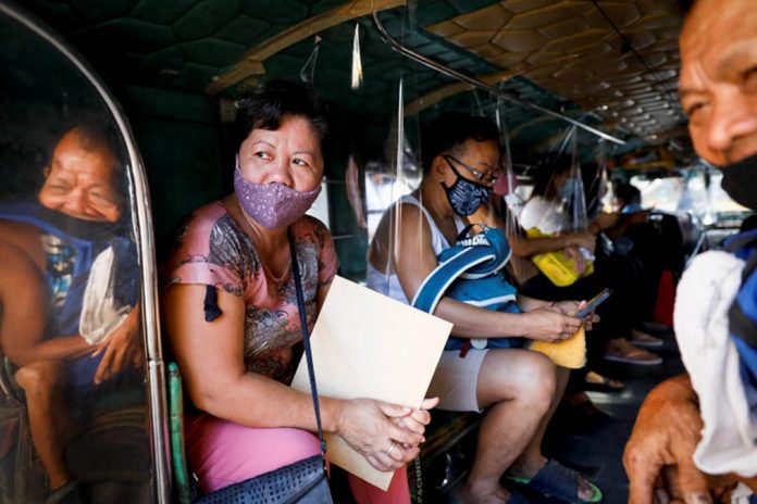 business Passengers wearing masks are seated in between plastic barriers to maintain social distancing in a jeepney in Quezon City, Metro Manila. REUTERS PHOTO