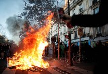 A fire is seen during a demonstration in Paris, Nov. 28, 2020 against the Global Security Bill that rights groups say would make it a crime to circulate an image of a police officer’s face and would infringe journalists’ freedom in France. BENOIT TESSIER/REUTERS