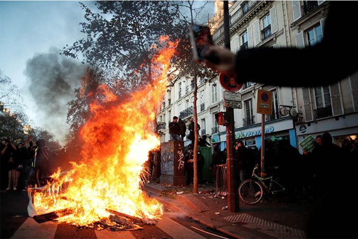 A fire is seen during a demonstration in Paris, Nov. 28, 2020 against the Global Security Bill that rights groups say would make it a crime to circulate an image of a police officer’s face and would infringe journalists’ freedom in France. BENOIT TESSIER/REUTERS A fire is seen during a demonstration in Paris, Nov. 28, 2020 against the Global Security Bill that rights groups say would make it a crime to circulate an image of a police officer’s face and would infringe journalists’ freedom in France. BENOIT TESSIER/REUTERS
