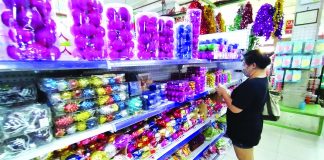 Wearing facemask, this woman shops for Christmas decorations in Iloilo City. With the holiday shopping season soon to peak, the Bangko Sentral ng Pilipinas warns the public to watch out for fake money. IAN PAUL CORDERO/PN