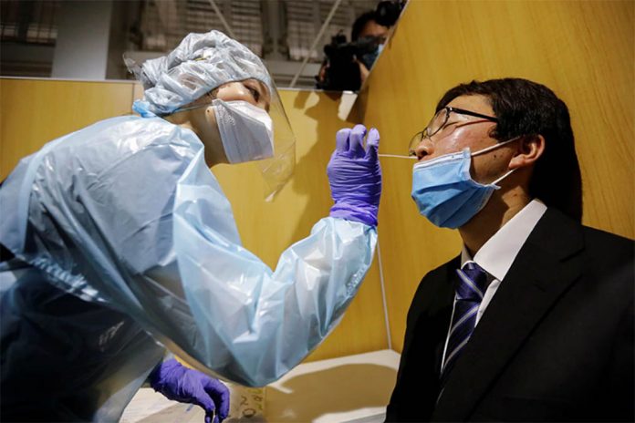 A medical worker wearing a protective suit conducts a simulation for a polymerase chain reaction (PCR) test at newly-opened Narita International Airport PCR Center. ISSEI KATO/REUTERS A medical worker wearing a protective suit conducts a simulation for a polymerase chain reaction (PCR) test at newly-opened Narita International Airport PCR Center. ISSEI KATO/REUTERS