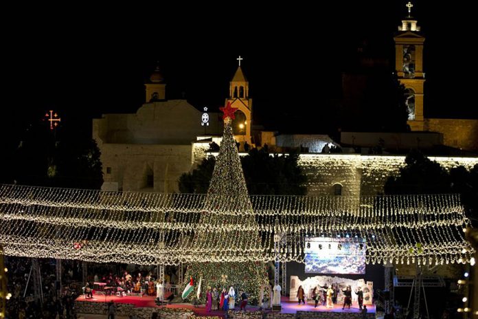 palestine Palestinian Christians celebrate the lighting of a Christmas tree outside the Church of the Nativity, traditionally believed by Christians to be the birthplace of Jesus Christ in the West Bank city of Bethlehem. MAJDI MOHAMMED/AP PHOTO