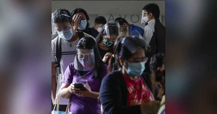 Filipinos in personal protective gear wait to enter a government office in Quezon City. The Philippine government targets to vaccinate at least 50 percent of its total population once a coronavirus vaccine becomes available. AP PHOTO