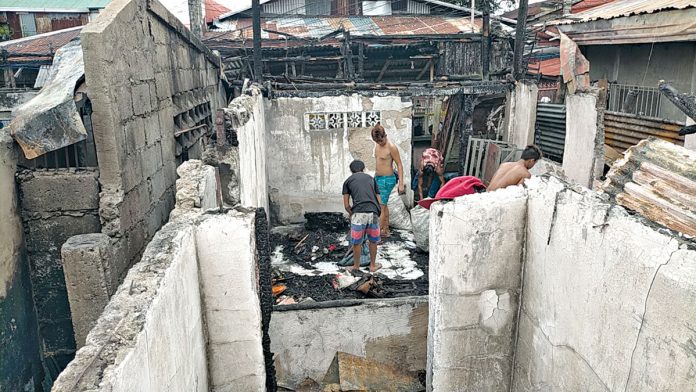 Chritmas-Eve-Fire Residents sift through the ruins of their homes, looking for any recoverable belongings after a fire struck Zone 6-B in Barangay Boulevard, Molo, Iloilo City on Christmas eve.